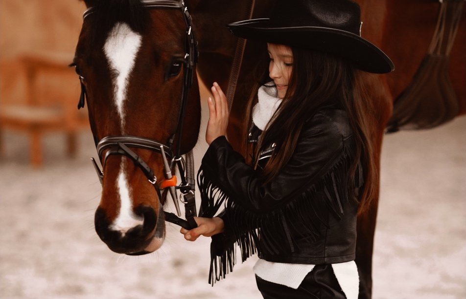 Menina com a mão no focinho de um cavalo